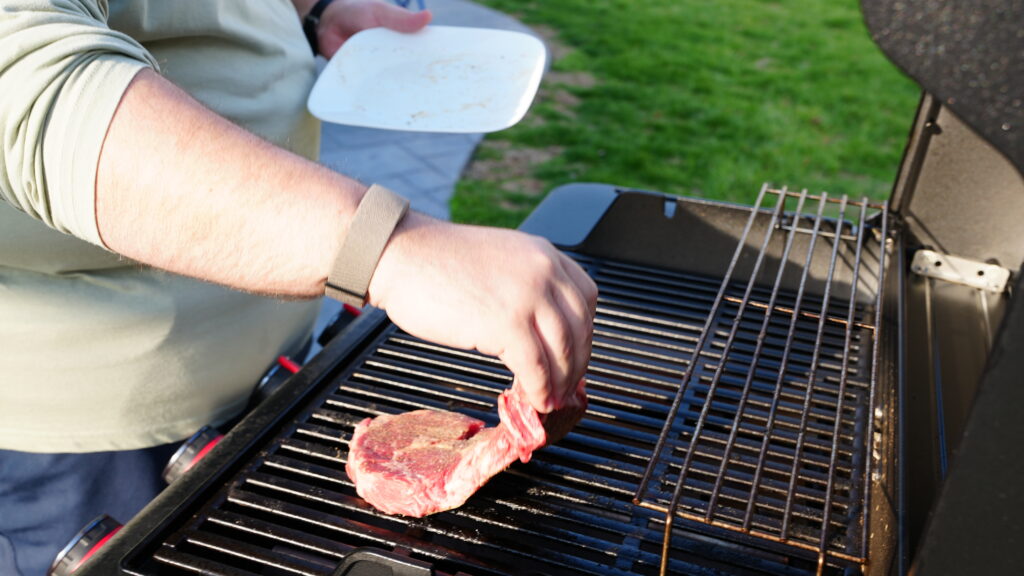 Justin putting the steak on the grill