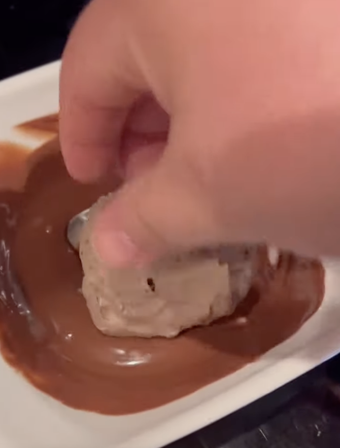 dipping cheesecake bite in chocolate