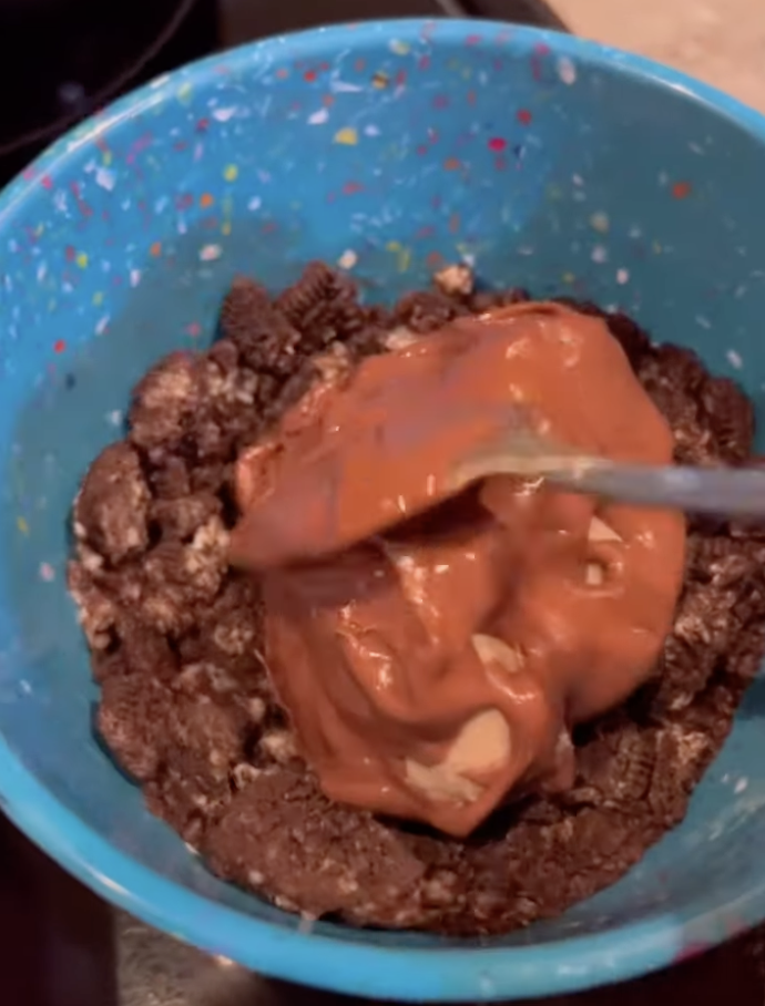 rolling cheesecake bite in crushed up Oreos