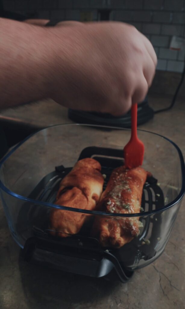 brushing mixture onto the cheesy pizza stuffers