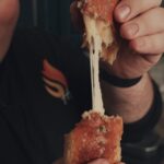 cheesy pizza stuffer being pulled apart to see the cheese