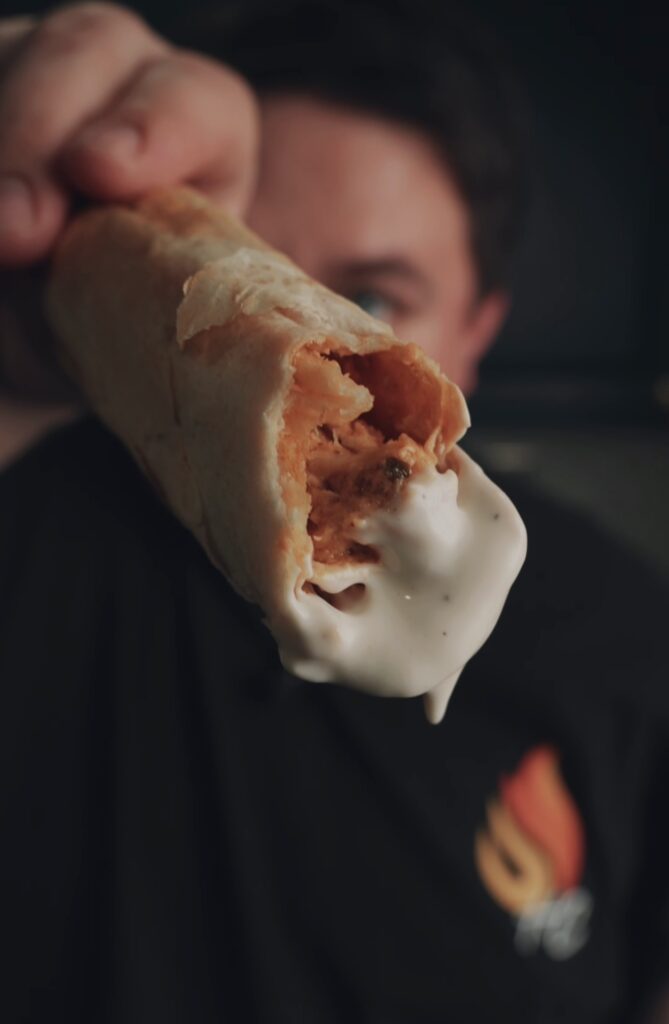 Justin holding a chicken bacon ranch taquito