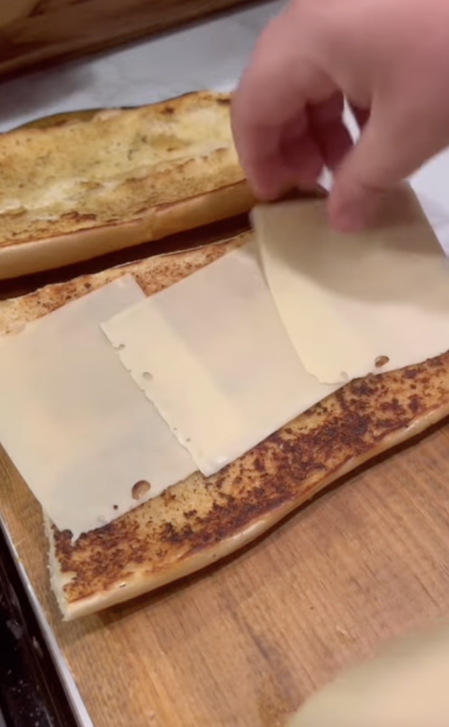adding cheese to bread